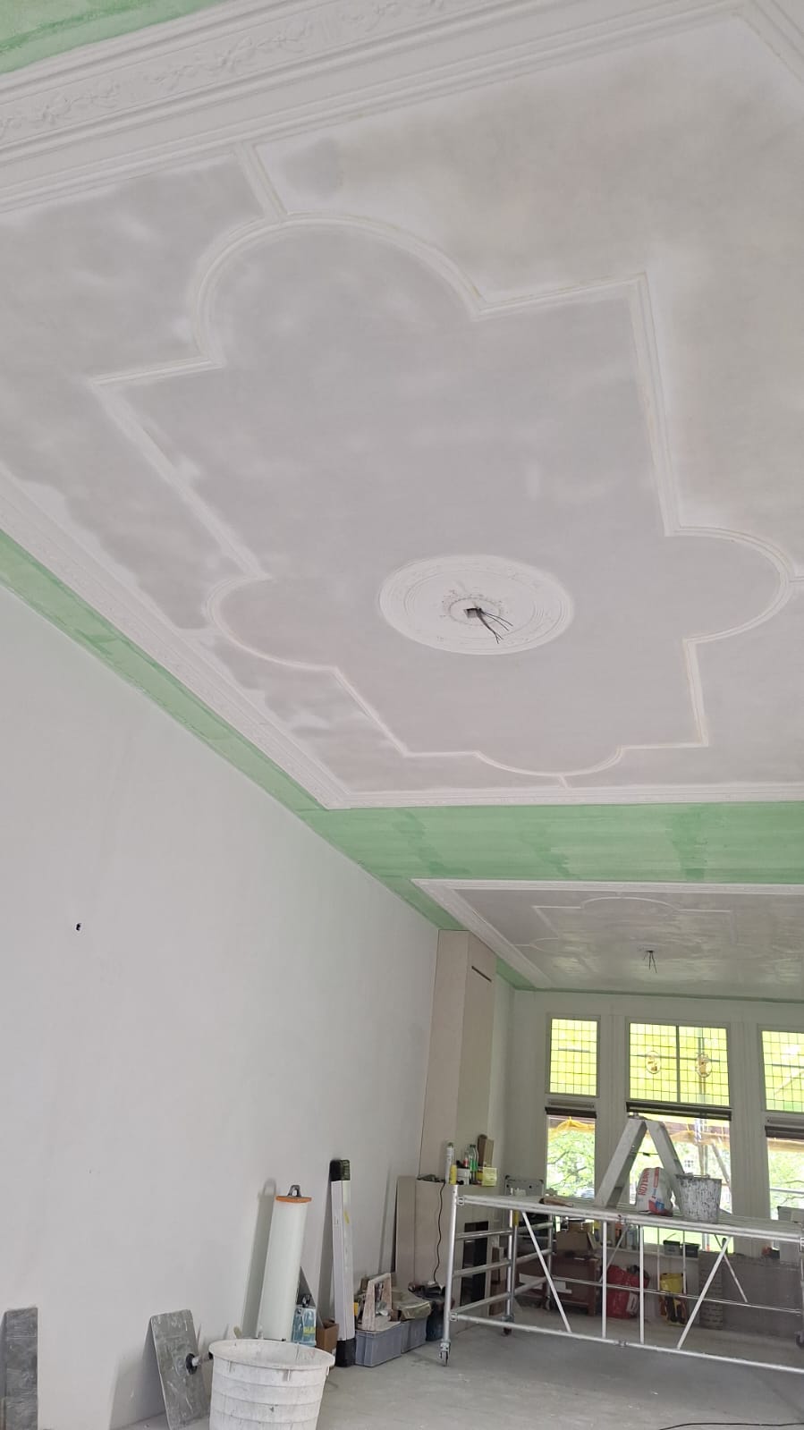 Detail van gerestaureerde plafondrozet en lijstwerk